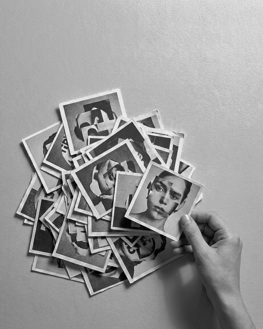 A hand lifting one print from a loose pile of black and white collages